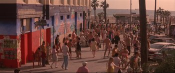 Movie still from “Falling Down” (1993), directed by Joel Schumacher – A crowd of people walking down a street near the ocean; Extreme Wide shot, High angle