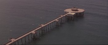 Movie still from “Falling Down” (1993), directed by Joel Schumacher – An aerial view of a pier in the middle of the ocean; Extreme Wide shot, High angle