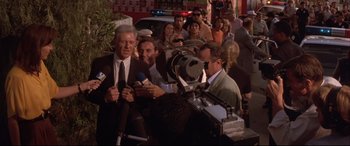Movie still from “Falling Down” (1993), directed by Joel Schumacher – A group of people standing around a camera; Medium shot, High angle