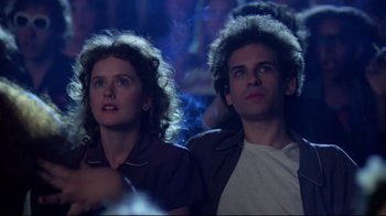 A man and a woman are watching a show