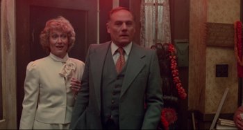 Movie still from “Fandango” (1985), directed by Kevin Reynolds – An older man and a woman standing next to each other; Medium shot, Low angle