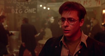 Movie still from “Fandango” (1985), directed by Kevin Reynolds – A man with glasses is looking at the camera; Close Up shot, Over the shoulder angle