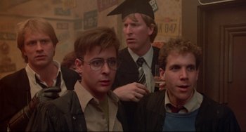 Movie still from “Fandango” (1985), directed by Kevin Reynolds – A group of men standing next to each other in a room; Close Up shot, Over the shoulder angle