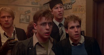 Movie still from “Fandango” (1985), directed by Kevin Reynolds – A group of men standing next to each other in a room; Close Up shot, Low angle