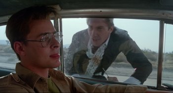 Movie still from “Fandango” (1985), directed by Kevin Reynolds – A man and a woman looking out the window of a car; Close Up shot, Over the shoulder angle