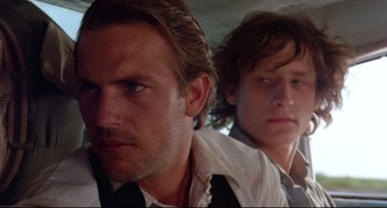 Movie still from “Fandango” (1985), directed by Kevin Reynolds – Two men are sitting next to each other in a car; Close Up shot, Low angle