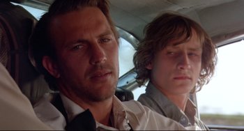Movie still from “Fandango” (1985), directed by Kevin Reynolds – Two men sitting next to each other in a car; Close Up shot, Low angle