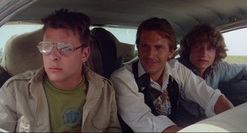 Movie still from “Fandango” (1985), directed by Kevin Reynolds – Two men sitting in the back seat of a car; Close Up shot, Low angle