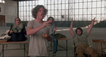 Movie still from “Fandango” (1985), directed by Kevin Reynolds – A group of people sitting around a table with food; Medium shot, Low angle