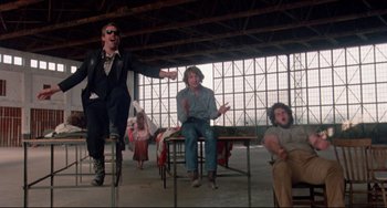 Movie still from “Fandango” (1985), directed by Kevin Reynolds – A group of people sitting at tables in a room; Wide shot, Low angle