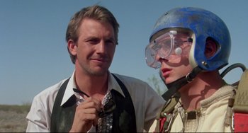Movie still from “Fandango” (1985), directed by Kevin Reynolds – A man and a woman wearing goggles and a tie; Close Up shot, Over the shoulder angle