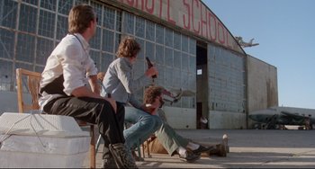 Movie still from “Fandango” (1985), directed by Kevin Reynolds – A group of people sitting on the ground; Wide shot, Low angle