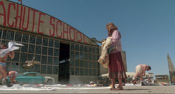 Movie still from “Fandango” (1985), directed by Kevin Reynolds – A woman standing in front of an abandoned school; Wide shot, Low angle