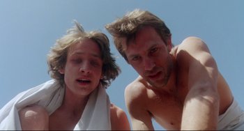 Movie still from “Fandango” (1985), directed by Kevin Reynolds – A man and a boy are posing for a picture; Close Up shot, Low angle