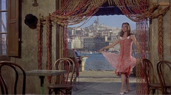 Movie still from “Fanny” (1961), directed by Joshua Logan – A woman in a pink dress standing in front of the water; Wide shot, Low angle