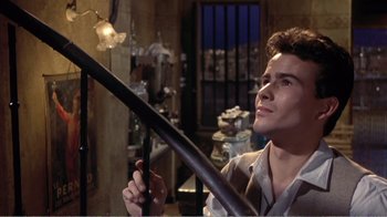 Movie still from “Fanny” (1961), directed by Joshua Logan – A man holding a baseball bat in a room; Medium shot, Low angle