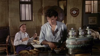 Movie still from “Fanny” (1961), directed by Joshua Logan – A man sitting at a table in front of a bowl of food; Medium shot, High angle