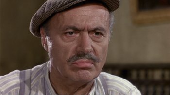 Movie still from “Fanny” (1961), directed by Joshua Logan – An older man wearing a hat and looking at the camera; Close Up shot, High angle