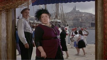 Movie still from “Fanny” (1961), directed by Joshua Logan – An older woman in a purple dress and a black hat; Medium shot, Low angle