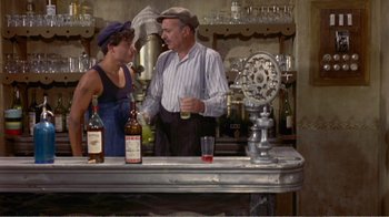Movie still from “Fanny” (1961), directed by Joshua Logan – A man and a woman standing at a bar; Medium shot, High angle