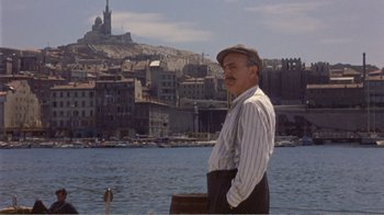 Movie still from “Fanny” (1961), directed by Joshua Logan – An older man standing in front of a body of water; Medium shot, Low angle