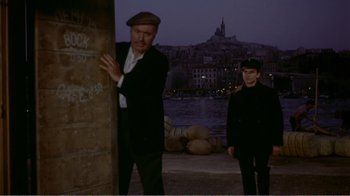 Movie still from “Fanny” (1961), directed by Joshua Logan – Two men standing next to each other near a body of water; Medium shot, High angle