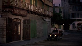 Movie still from “Fanny” (1961), directed by Joshua Logan – An old car is parked in front of a building; Extreme Wide shot, High angle