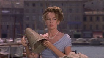 Movie still from “Fanny” (1961), directed by Joshua Logan – A woman in a blue dress holding a silver bell; Close Up shot, Low angle