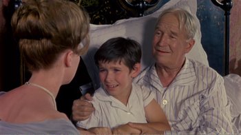 Movie still from “Fanny” (1961), directed by Joshua Logan – An older couple and a young boy in a hospital bed; Medium shot, High angle
