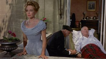 Movie still from “Fanny” (1961), directed by Joshua Logan – A woman standing next to a man sitting on a couch; Medium shot, High angle