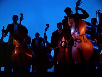 Movie still from “Fantasia” (1940), directed by Ford Beebe Jr. – A group of men standing next to each other holding instruments; Wide shot, Low angle