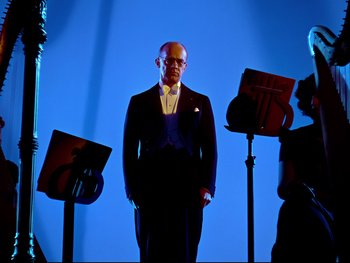 Movie still from “Fantasia” (1940), directed by Ford Beebe Jr. – A man standing in front of a group of musical instruments; Medium shot, Low angle