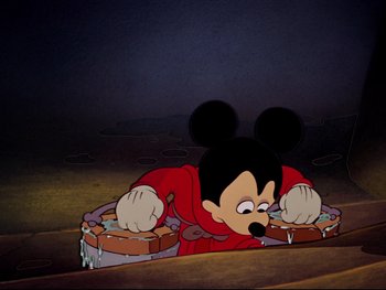 Movie still from “Fantasia” (1940), directed by Ford Beebe Jr. – A cartoon of a mickey mouse in a red outfit; Wide shot, Overhead angle