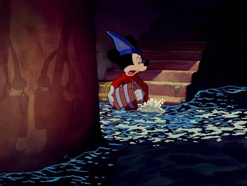 Movie still from “Fantasia” (1940), directed by Ford Beebe Jr. – A cartoon of a mickey mouse with a blue hat; Wide shot, High angle