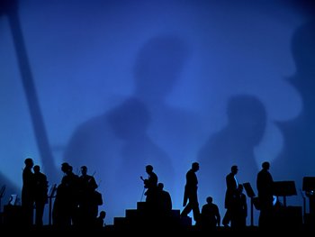 Movie still from “Fantasia” (1940), directed by Ford Beebe Jr. – Silhouetted figures of people in a blue background; Extreme Wide shot, Low angle