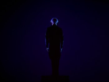 Movie still from “Fantasia” (1940), directed by Ford Beebe Jr. – A man standing in the dark with a blue light; Wide shot, Low angle