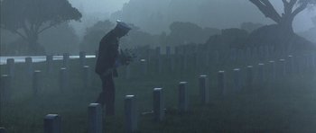 Movie still from “The Rock” (1996), directed by Michael Bay – A man in a military uniform walking through a cemetery; Wide shot, Low angle