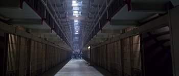 Movie still from “The Rock” (1996), directed by Michael Bay – People are standing in a long hallway in a prison; Extreme Wide shot, High angle
