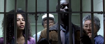 Movie still from “The Rock” (1996), directed by Michael Bay – A group of men standing next to each other in front of a jail cell; Medium shot, Low angle