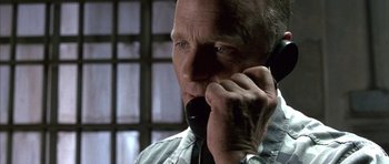 Movie still from “The Rock” (1996), directed by Michael Bay – An older man talking on a cell phone in front of a window; Close Up shot, High angle