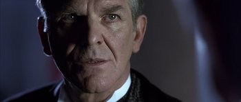 Movie still from “The Rock” (1996), directed by Michael Bay – An older man wearing a suit and tie; Close Up shot, Low angle