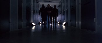 Movie still from “The Rock” (1996), directed by Michael Bay – A group of people walking down a hallway at night; Wide shot, Low angle