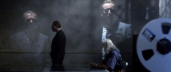 Movie still from “The Rock” (1996), directed by Michael Bay – A man and a woman standing next to each other in front of a wall; Medium shot, Over the shoulder angle