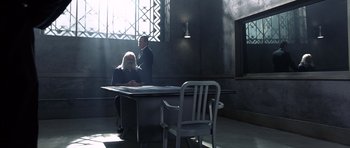 Movie still from “The Rock” (1996), directed by Michael Bay – A man and a woman sitting at a table in front of a window; Wide shot, High angle