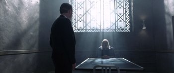 Movie still from “The Rock” (1996), directed by Michael Bay – A man and a woman sitting at a table in front of a window; Wide shot, Over the shoulder angle