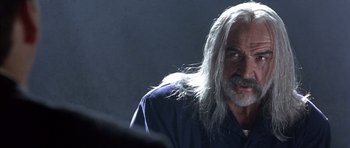 Movie still from “The Rock” (1996), directed by Michael Bay – An older man with long white hair and a beard; Close Up shot, Over the shoulder angle