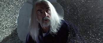 Movie still from “The Rock” (1996), directed by Michael Bay – An older man with long white hair looking out of a window; Close Up shot, Low angle