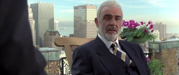 Movie still from “The Rock” (1996), directed by Michael Bay – An older man wearing a suit and tie sitting on top of a wooden bench; Close Up shot, Over the shoulder angle