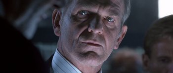 Movie still from “The Rock” (1996), directed by Michael Bay – An older man wearing a white shirt and a white tie; Close Up shot, Low angle