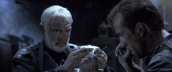 Movie still from “The Rock” (1996), directed by Michael Bay – An older man looking at something in his hands; Close Up shot, Low angle